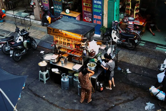 Vietnamese street food vendor preparing dishes at a Hanoi stall