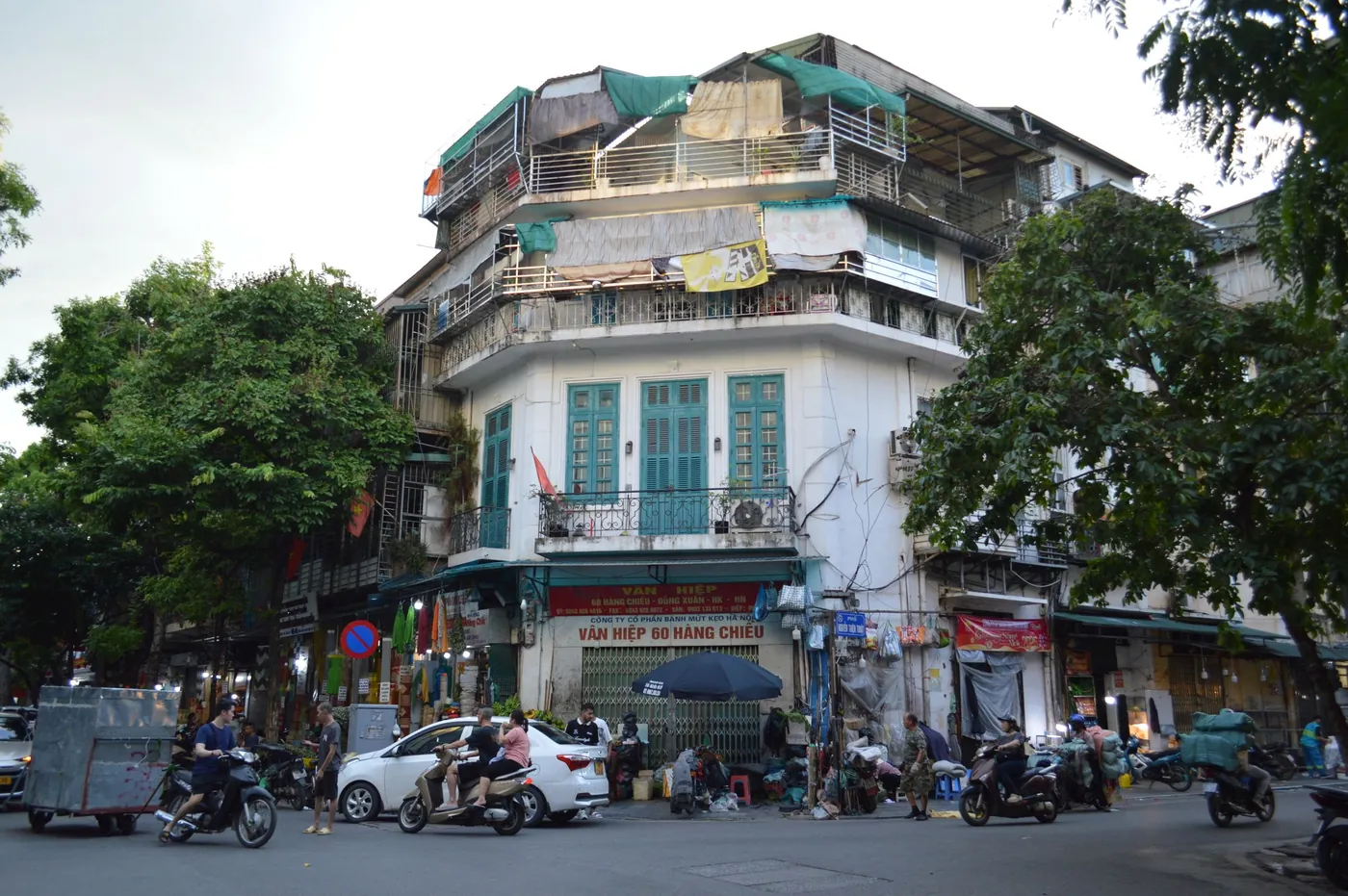 Busy street scene in Hanoi's Old Quarter with motorbikes and shopfronts
